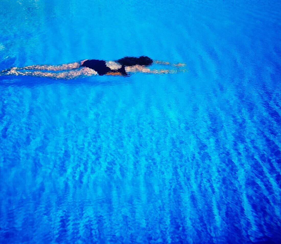 Junge Frau schwimmt in tropischem Wasser