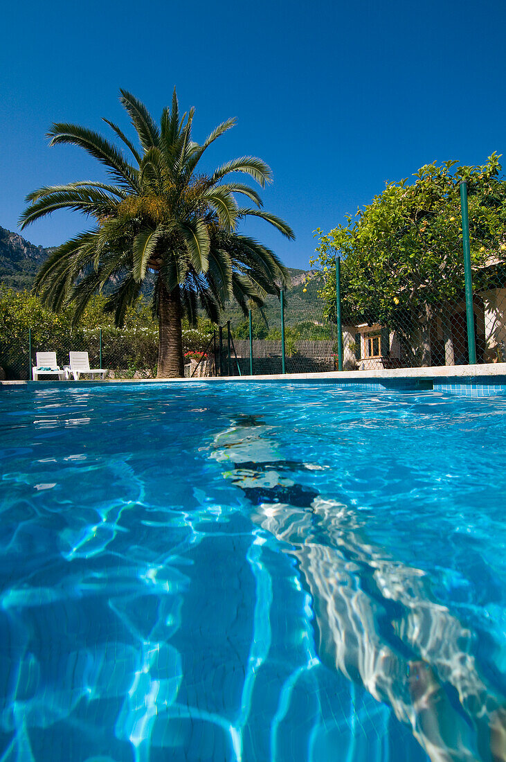 Frau schwimmt unter Wasser im Freibad, Rückansicht, Soller, Mallorca, Balearen, Spanien