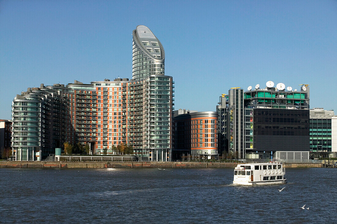 Sightseeing-Boot fährt an Bürotürmen in Canary Wharf vorbei, London,Uk