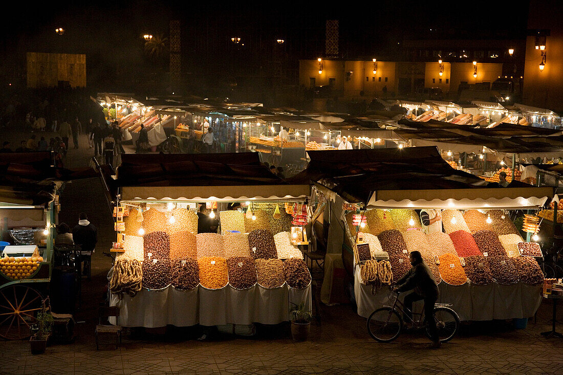 Blick über nächtlich beleuchtete Stände auf dem Djemaa El Fna, Marrakesch, Marokko