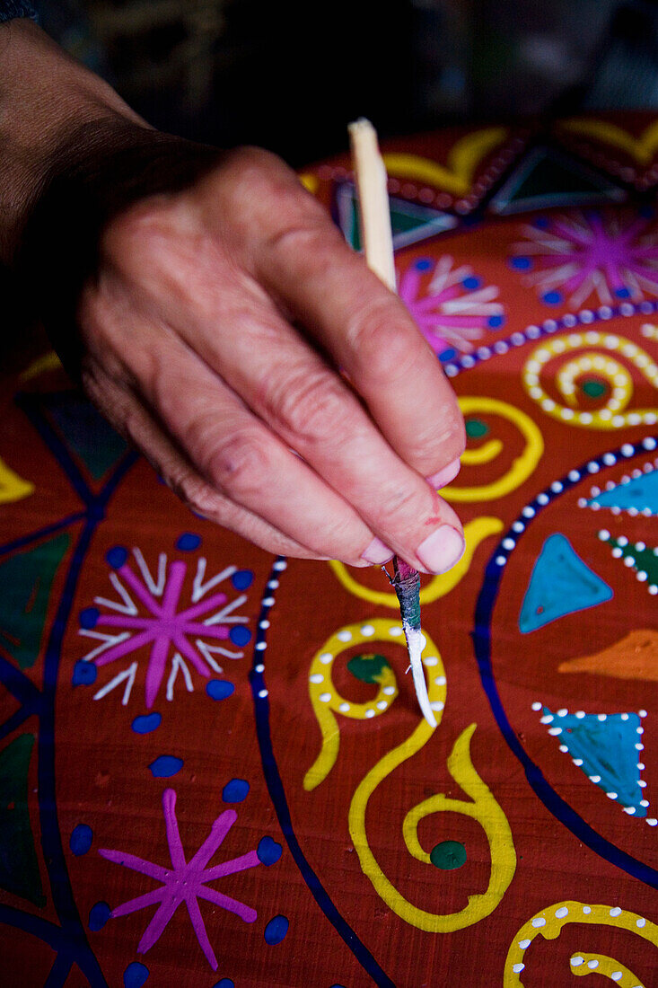 Mann bemalt Tisch im Souk, Nahaufnahme der Hand, Marrakesch, Marokko