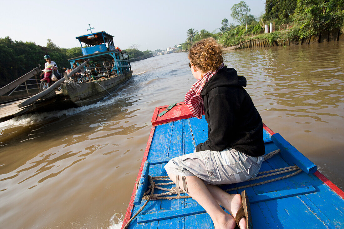 Junge Frau genießt Bootsfahrt im Mekong-Delta, Vinh Long, Vietnam