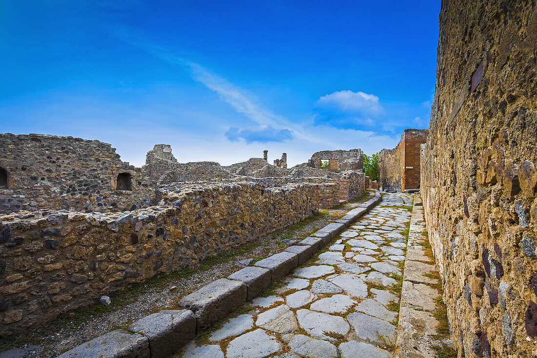 A Stone Path Leading Beside The Ruins Of Walls; Pompei, Campania, Italy