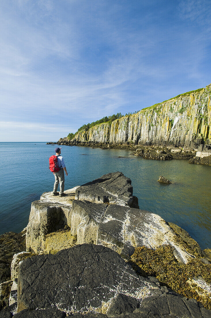 Hiker Along Basalt Rock Cliffs, Bay Of Fundy; Brier Island, Nova Scotia, Canada