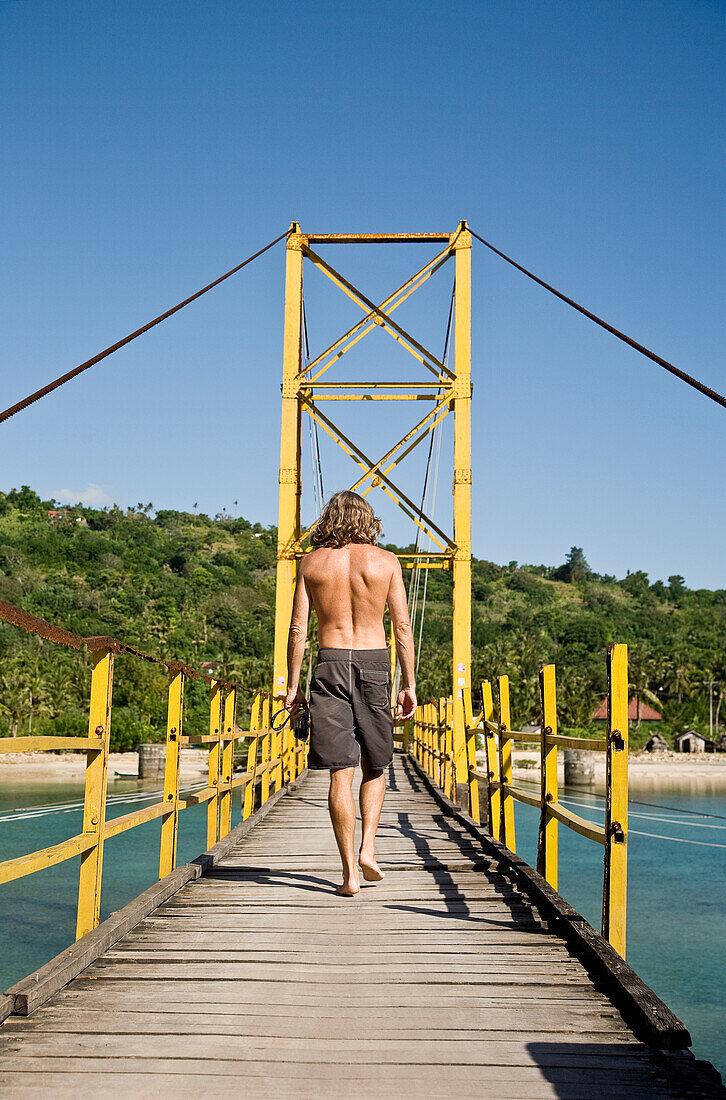 Männlicher Tourist auf der Brücke nach Nusa Cenida