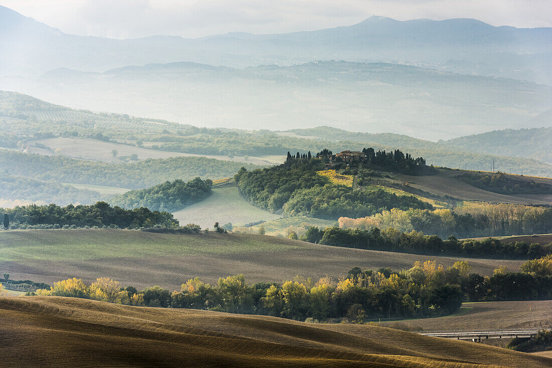 Layers Of Green And Gray Tuscany Hills Disappearing In The Mist; San Quirico D'orcia, Tuscany, Italy