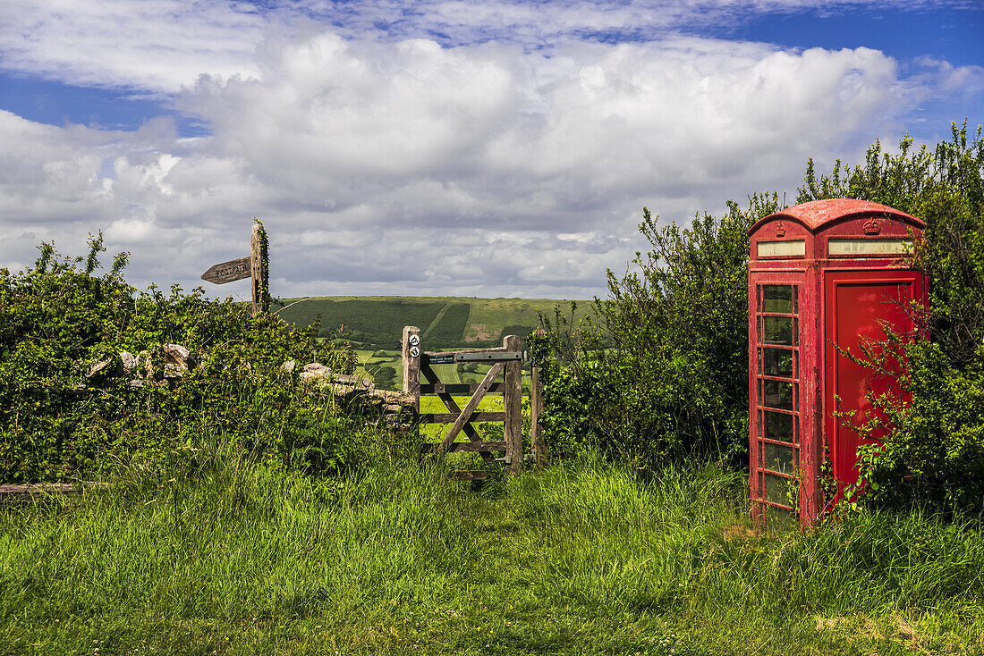 Eine altmodische Telefonzelle neben einem Weg auf dem Land; Dorset, England.