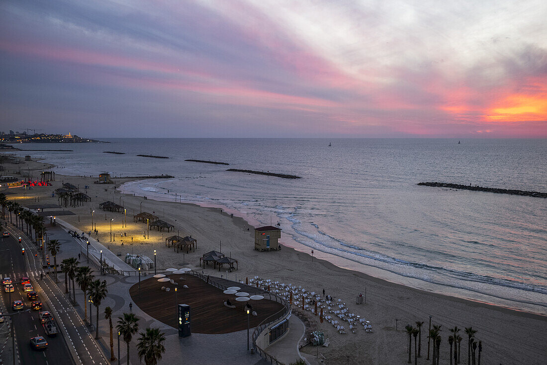 Sonnenuntergang über dem Mittelmeer und eine Straße entlang der Strandpromenade; Tel Aviv, Israel