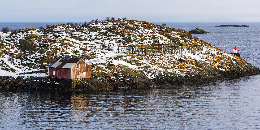 A Building Along The Water's Edge With A View Of The Ocean And Horizon; Lofoten Islands, Nordland, Norway