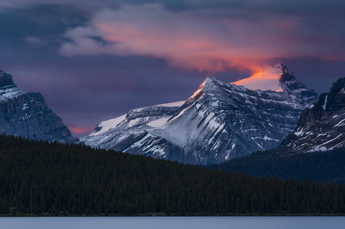 Sunrise illuminating the peaks of the Rocky Mountains over Bow Lake, Banff National Park; Improvement District No. 9, Alberta, Canada