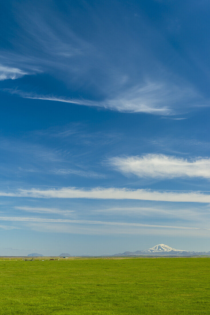 Looking across grasslands to Hekla volcano in the distance; Iceland