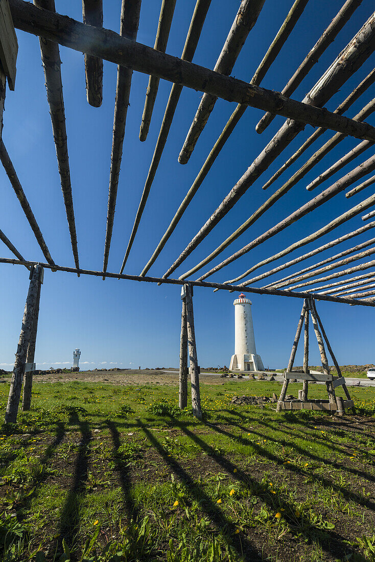 Old fish drying racks next to a lighthouse; Akranes, Iceland