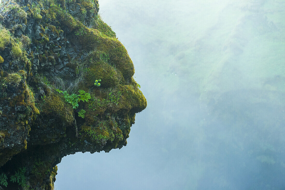 Form von Kopf und Gesicht in natürlichen Felsen neben dem Skogafoss-Wasserfall, Island