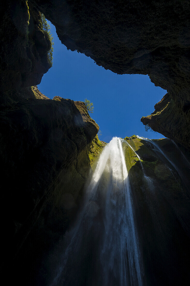 Blick auf einen kleinen Wasserfall in einem großen Loch in der Nähe des Seljalandsfoss; Island