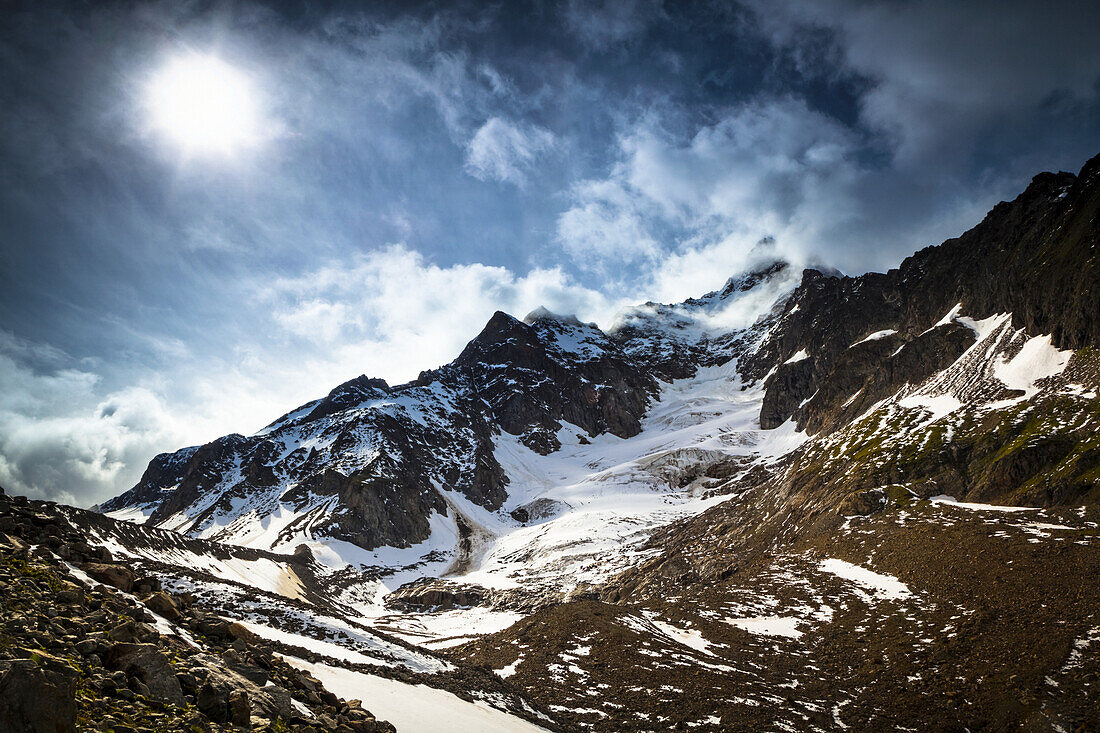 Storm clouds over Aiguille des Glaciers (mountain) and Estellette Glacier and moraine, Alps; Aosta Valley, Italy