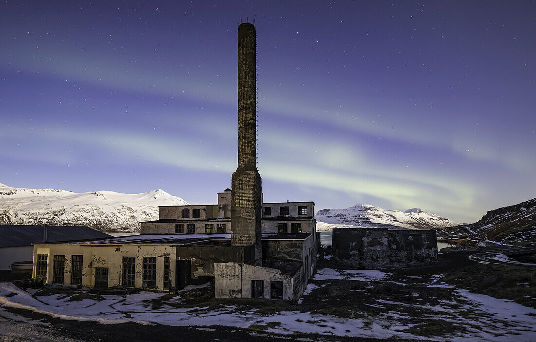 The abandoned herring factory with northern lights above it; Djupavik, West Fjords, Iceland