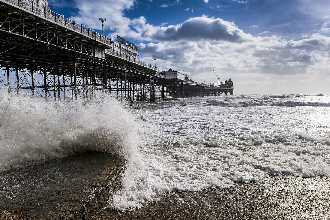 Brighton Palace Pier mit Wellen, die ans Ufer schlagen; Brighton, Sussex, England.