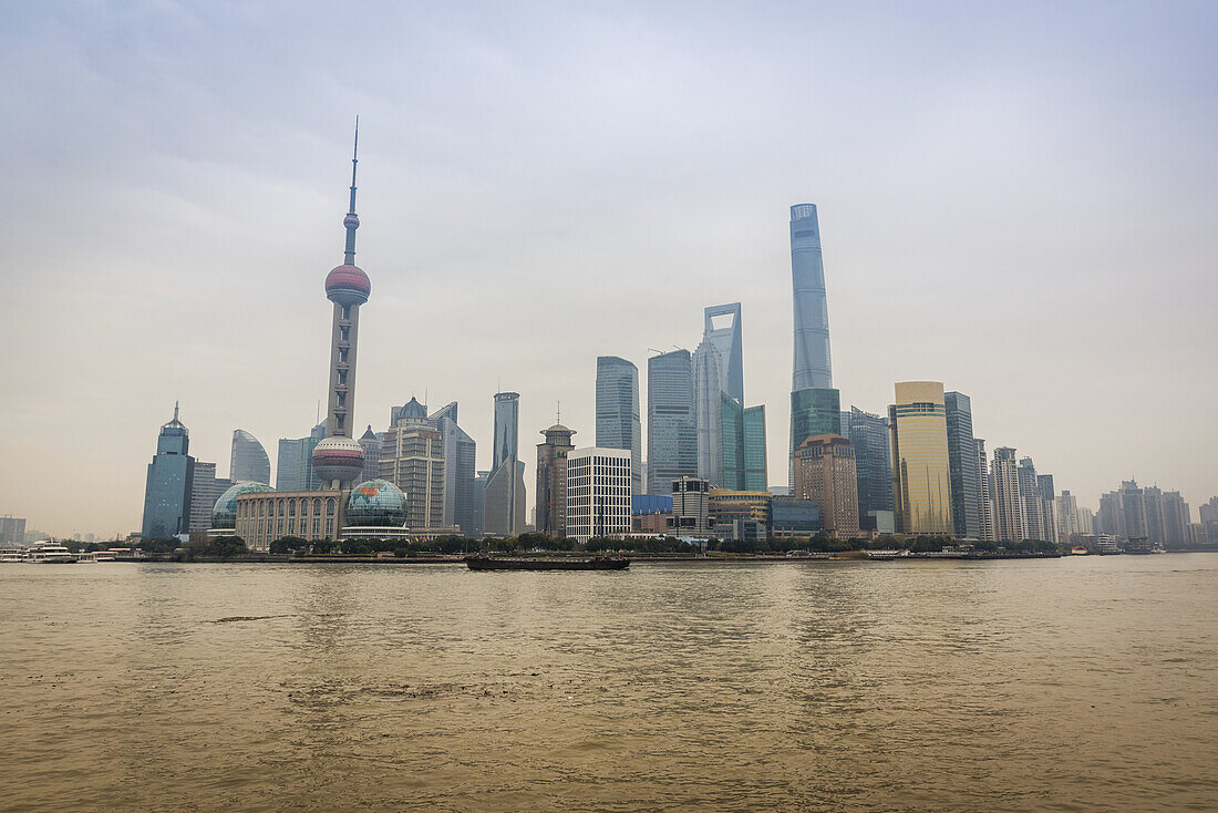 Pudong skyline with its landmark skyscrapers seen from the opposite side of the Huangpu river; Shanghai, China