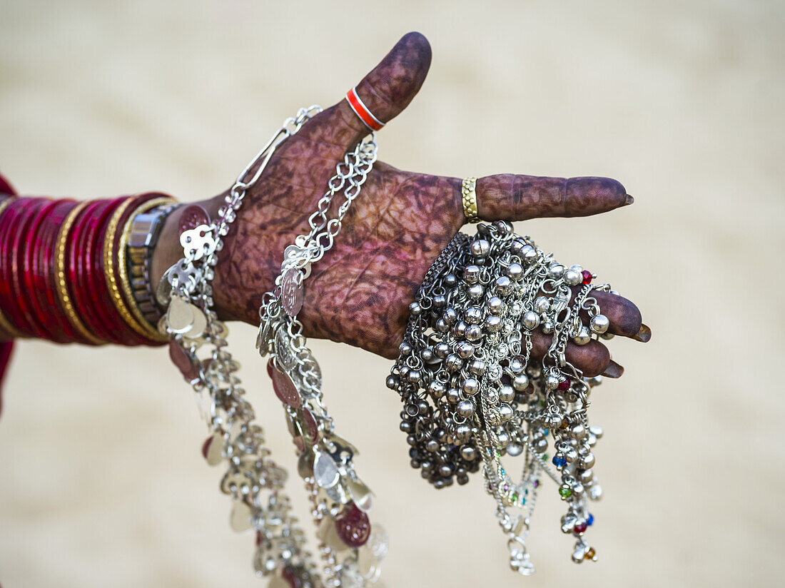 Mit Henna verzierte Frauenhand, die Silberschmuck hält; Jaisalmer, Rajasthan, Indien.