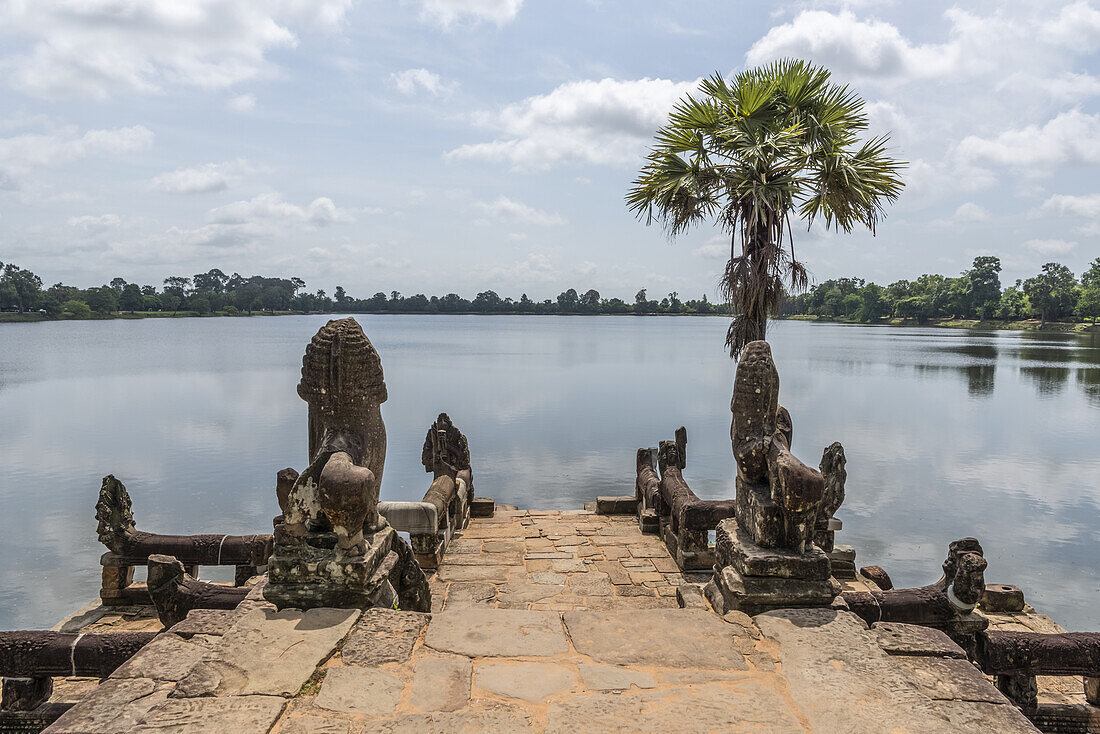 Statues and palm tree on stone jetty, Srah Srang, Angkor Wat; Siem Reap, Siem Reap Province, Cambodia