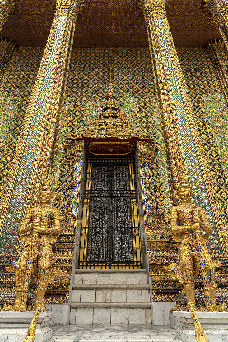 Tempel des Smaragdbuddhas mit goldenen Wächtern, Großer Palast; Bangkok, Thailand.
