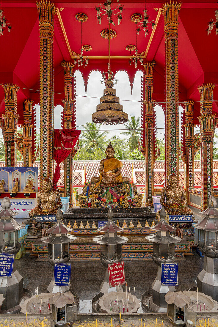 Three Buddha statues and offerings in temple, Otop Temple; Bangkok, Thailand