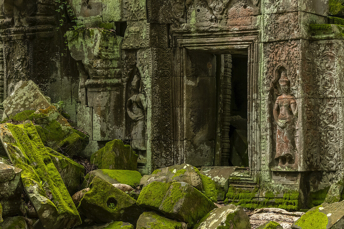 Statuen und umgestürzte Felsen am Eingang des Tempels, Ta Prohm, Angkor Wat; Siem Reap, Provinz Siem Reap, Kambodscha.