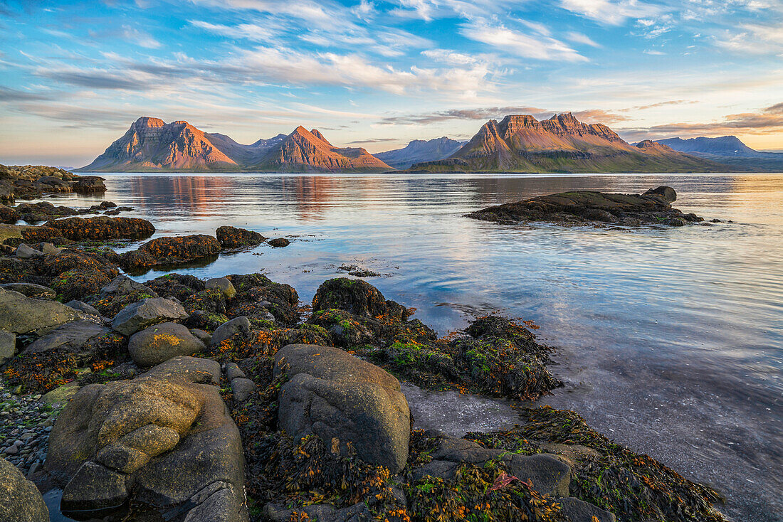 Die Berge der Strandir-Küste in der Nähe der Stadt Djupaik, der Sonnenuntergang beleuchtet die beeindruckende Landschaft; Djupavik, Westfjorde, Island