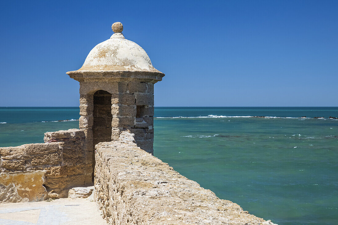 Steinmauer und Turm mit Blick auf das Mittelmeer; Cadiz, Andalusien, Spanien.