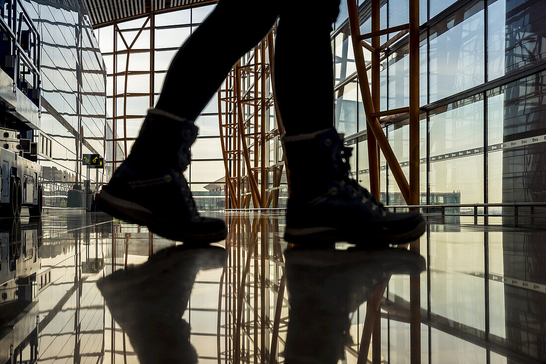 Füße gehen und spiegeln sich auf dem glänzenden Boden des Terminalgebäudes, Beijing Capital International Airport; Beijing, China.