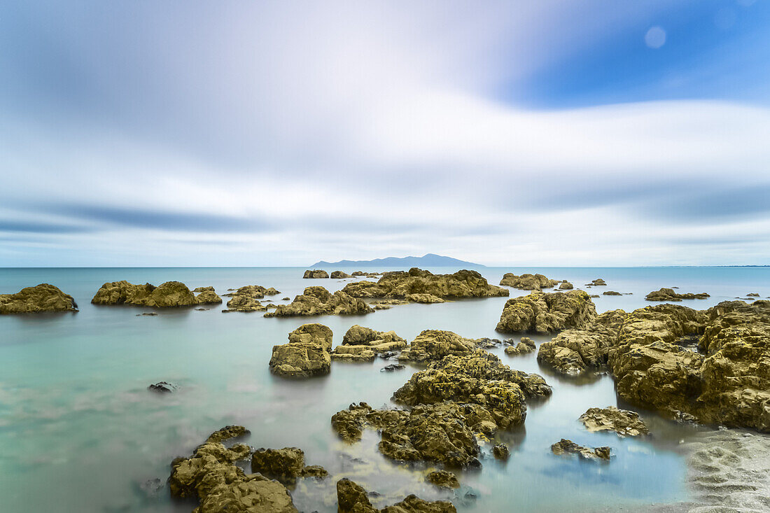 Felsen im Meer entlang der Küstenlinie in der Pukerua Bay, Kapiti Island; Wellington, Neuseeland