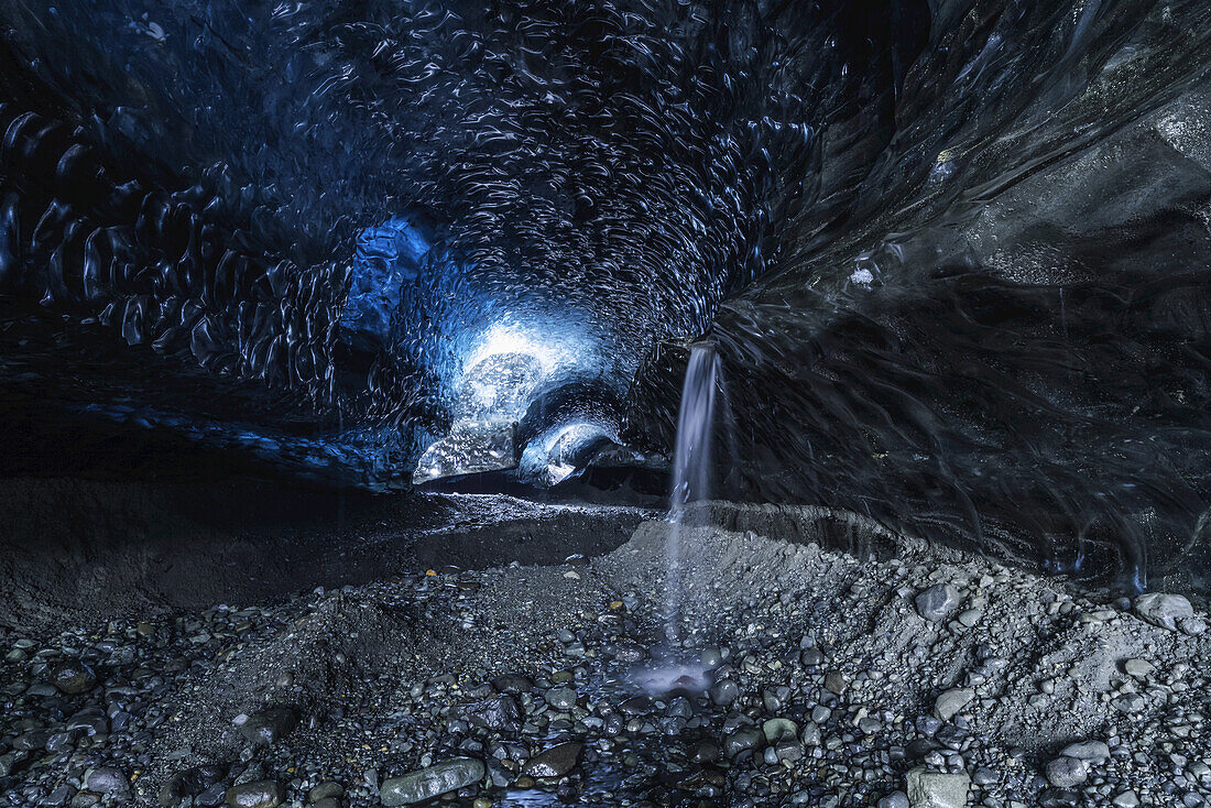 Der Eingang zu einer großen Eishöhle in der Vatnajokull-Eiskappe mit einem Wasserfall; Island