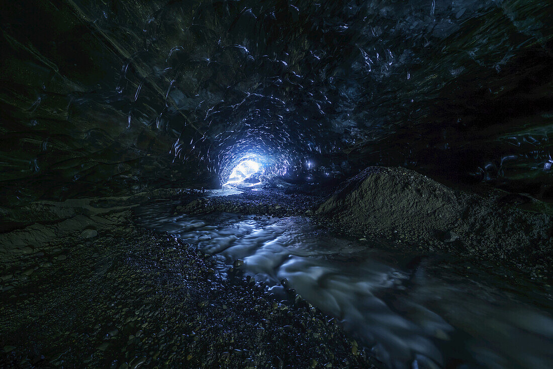 Looking toward the entrance of an ice cave while being 500 metres under a glacier; Iceland