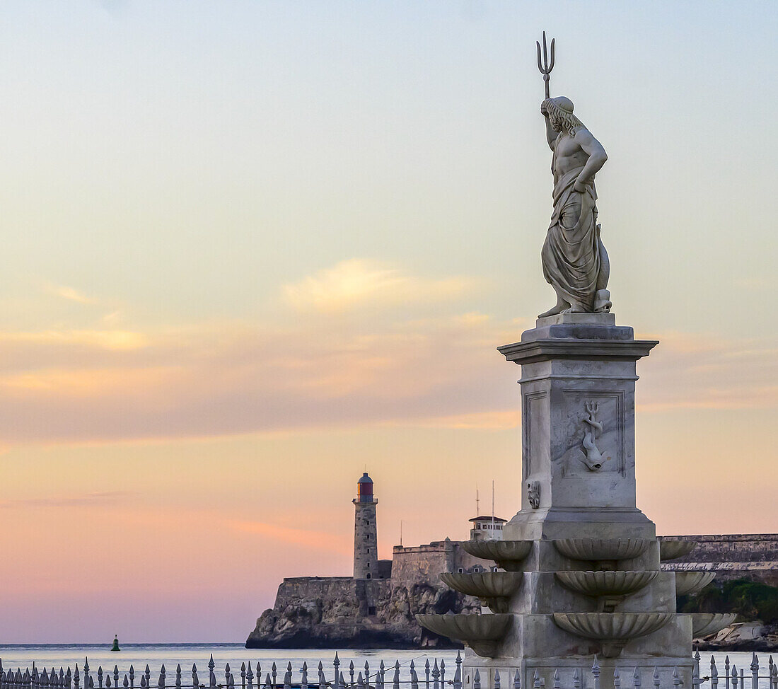 Schloss Morro bei Sonnenuntergang, mit einer Statue von Poseidon mit Dreizack im Vordergrund; Havanna, Kuba.