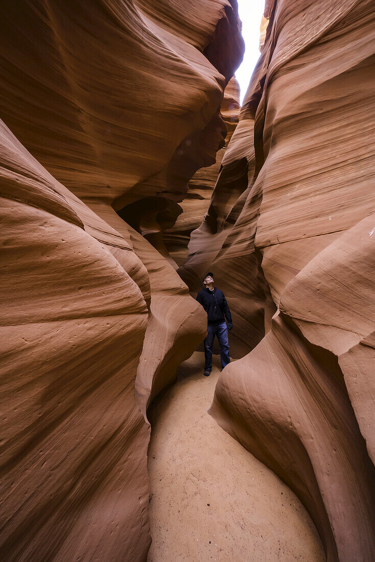 Man standing in a Slot Canyon known as Canyon X, near Page; Arizona, United States of America