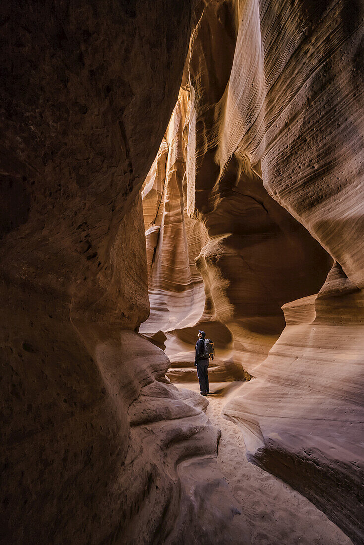 Man standing in a Slot Canyon known as Canyon X, near Page; Arizona, United States of America