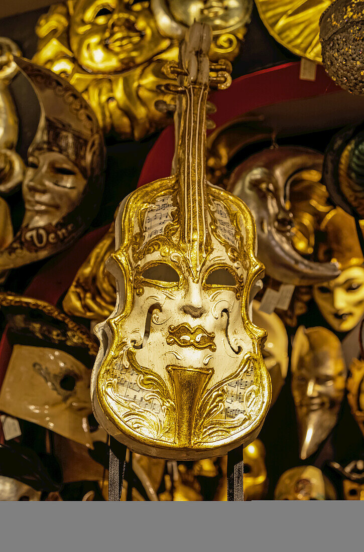 Gold violin on display with Venetian masks; Venice, Italy