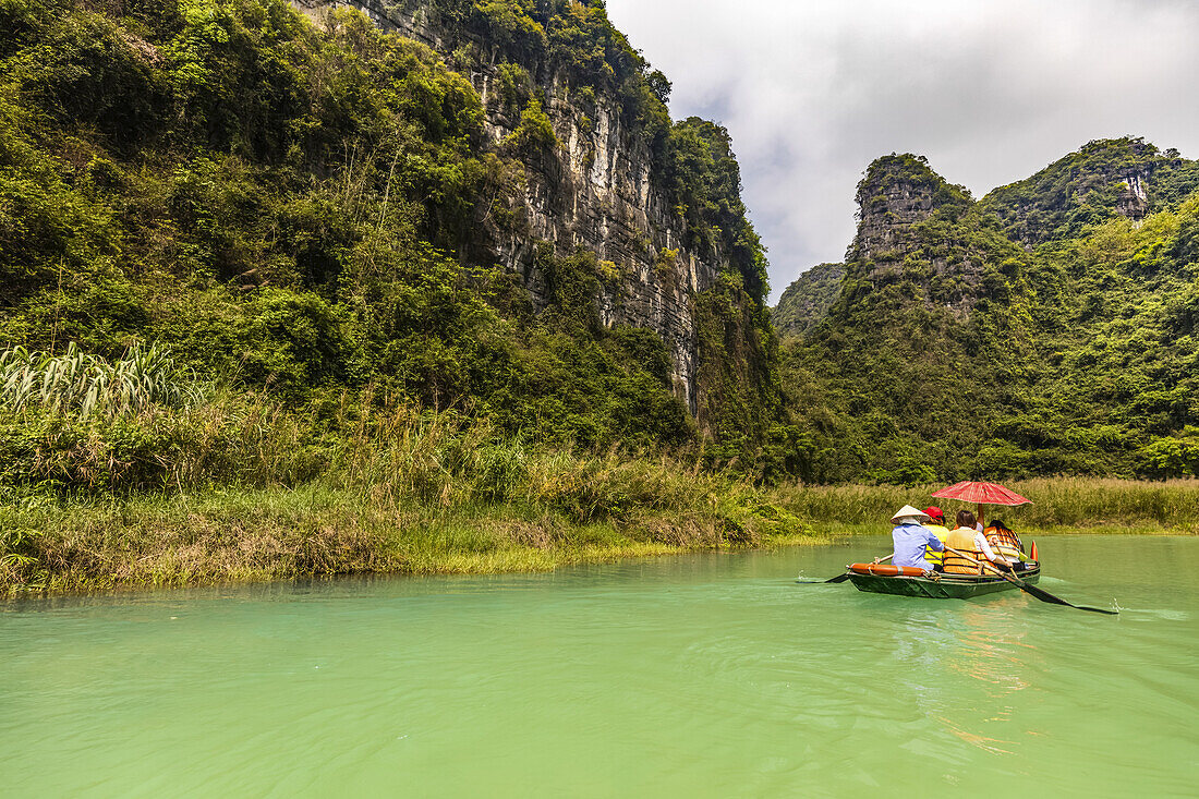 Bootsfahrt auf einem See mit Blick auf die üppige Landschaft von Ninh Binh; Ninh Binh Provinz, Vietnam.