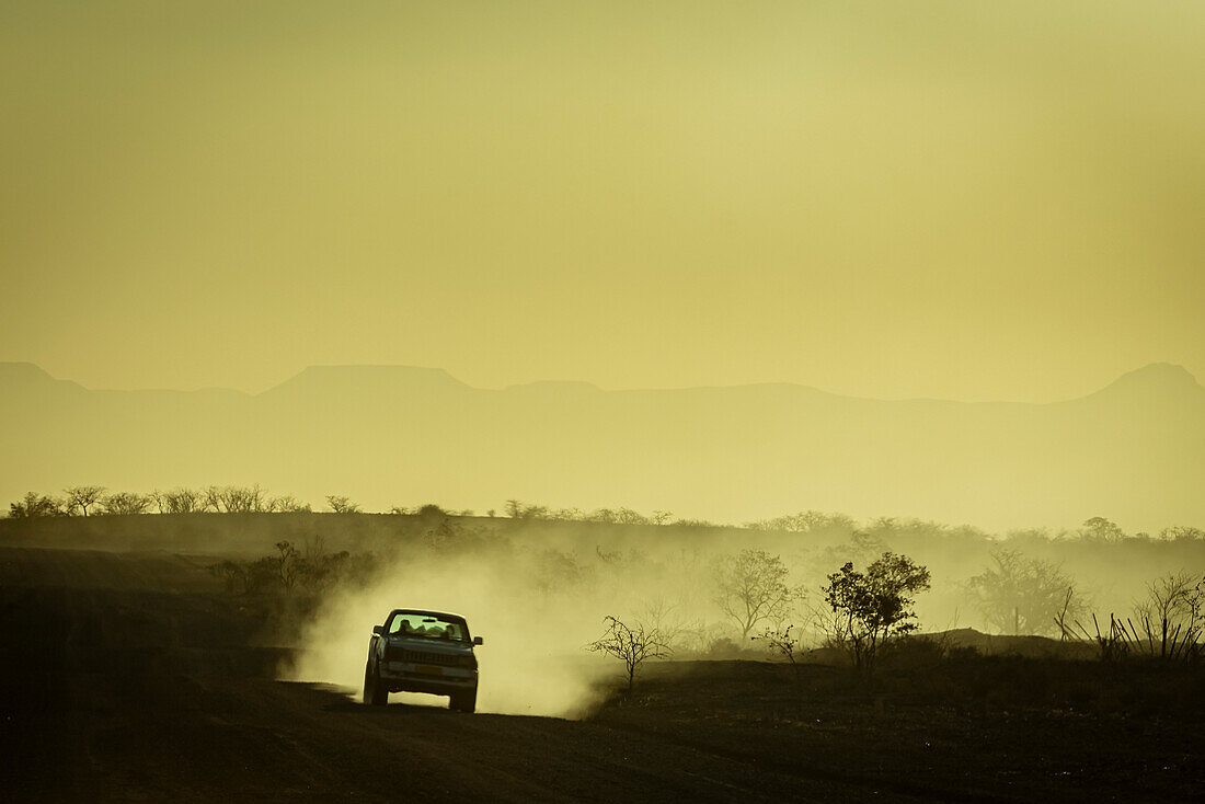Autofahrt bei Sonnenuntergang, Damaraland; Kunene Region, Namibia.