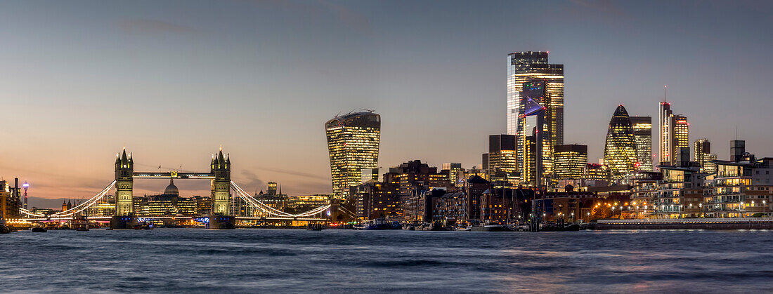 Cityscape and skyline of London at dusk with 20 Fenchurch, 22 Bishopsgate, and various other skyscrapers, and the River Thames in the foreground; London, England