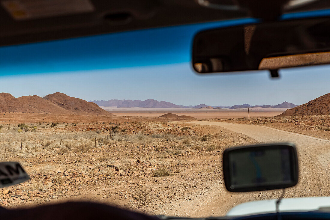 Fahren auf einer langen trockenen Straße, Namib-Wüste; Namibia