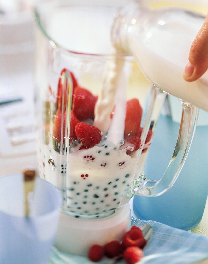 Making berry shake: putting milk & berries into measuring jug