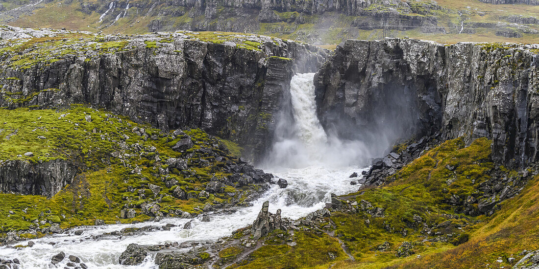 Wasserfall, der über eine Felsklippe fließt; Djupivogur, östliche Region, Island