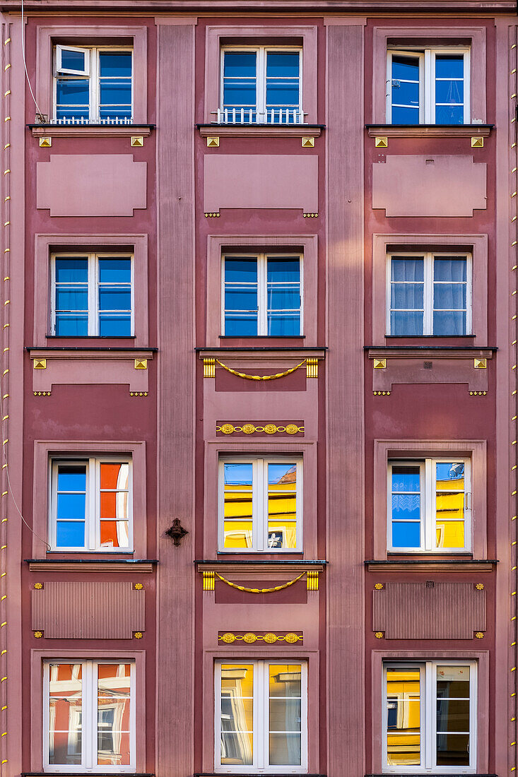 Gebäudefassade mit Fensterspiegelungen von bunten Häusern auf dem Marktplatz, Breslau; Breslau, Schlesien, Polen.