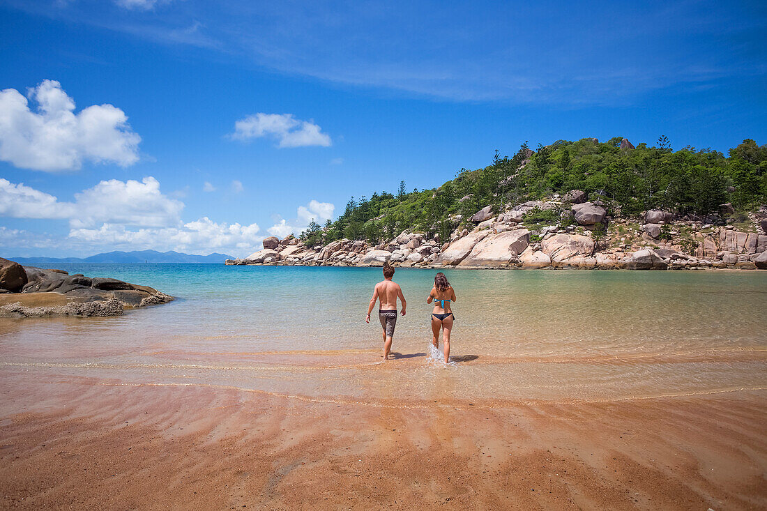 Alma Bay ist einer der vielen schönen Strände auf Magnetic Island. Ein Paar genießt das erfrischende, klare Wasser; Magnetic Island, Queensland, Australien