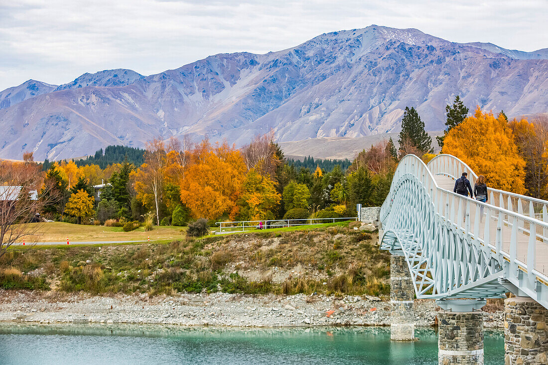 Beautiful views over the shoreline of New Zealand's Lake Tekapo. A beautiful bridge crosses a river; Canterbury, New Zealand
