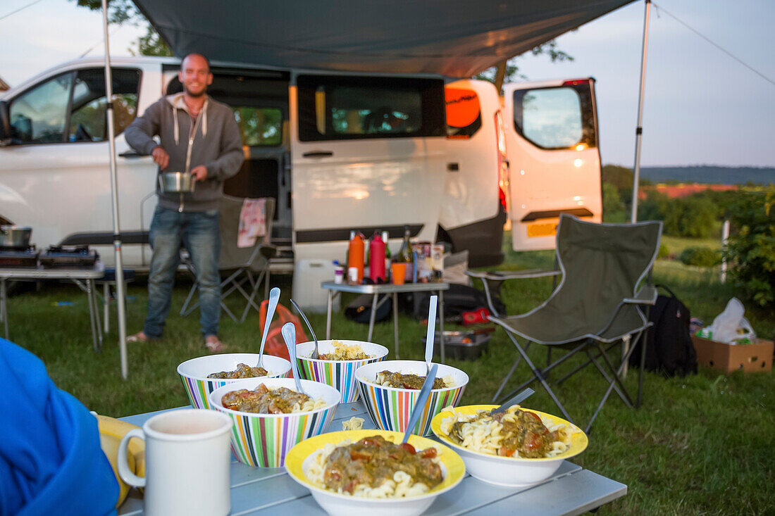 Ein Übernachtungsstopp auf einem Campingplatz in der Tschechischen Republik zwischen Prag und Cesky Krumlov. Der 50-Seelen-Ort heißt Kostelec und liegt am Rande von Hluboka nad Vltavou. Ein Camper richtet das Abendessen auf seinem Campingplatz ein; Kostelec, Vltavou, Tschechische Republik