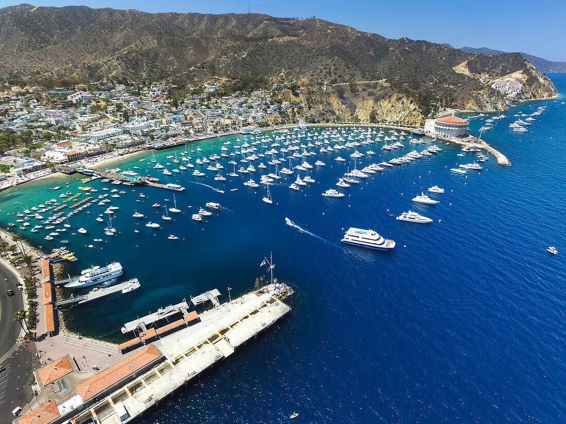 Überblick über Boote im Yachthafen von Avalon Harbor mit dem Catalina Casino ganz rechts, dem Green Pleasure Pier in der Mitte und der Cabrillo Mole am Avalon Pier im Vordergrund; Catalina Island, Kalifornien, Vereinigte Staaten von Amerika.