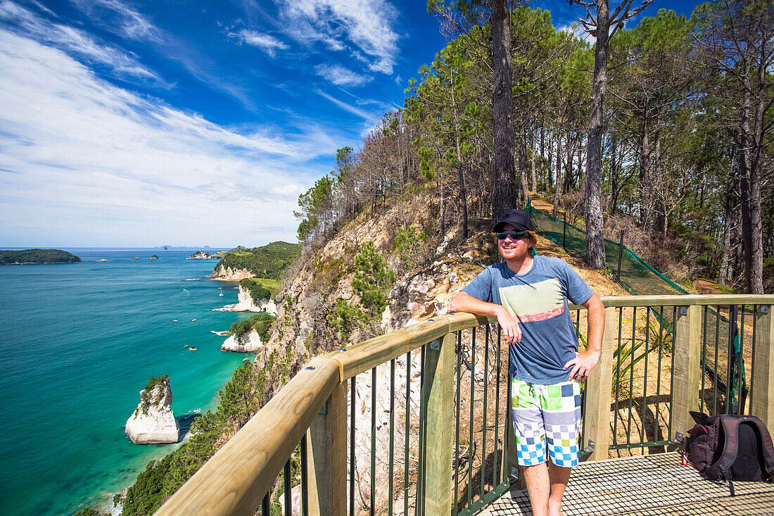 Ein Mann entspannt sich an einem Haihe-Aussichtspunkt, Cathedral Cove, Coromandel Peninsula, in Neuseeland; Neuseeland