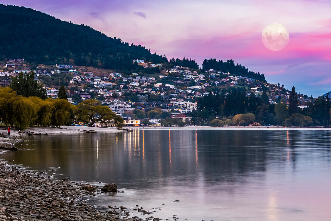 Der Vollmond geht in der Abenddämmerung über dem Wakatipu-See in Queenstown auf; Queenstown, Otago, Neuseeland
